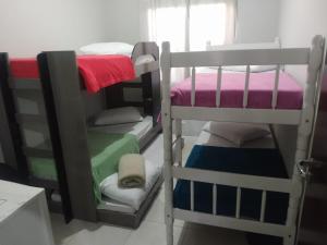 a room with two bunk beds and a window at Casa de Praia Balneário Piçarras in Piçarras