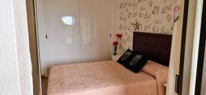 una piccola camera da letto con un letto con un cuscino nero di Apt. Faraj a Playa de las Americas Altre 20 foto