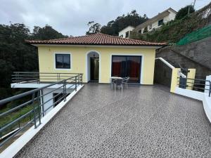 Un balcón de una casa con una mesa y sillas. en The Hideaway Retreat, en Santo da Serra
