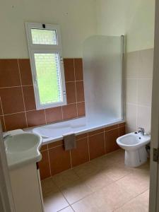 baño con lavabo y aseo y ventana en The Hideaway Retreat, en Santo da Serra