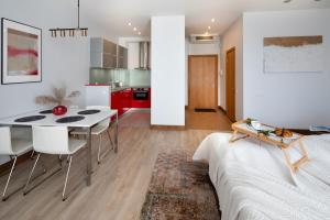 a kitchen and living room with a table and chairs at Central House Riverside Studio in Rīga