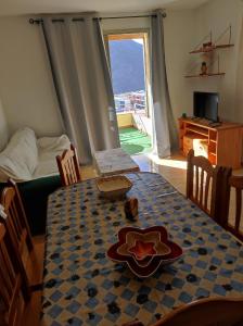 un comedor con mesa y una habitación con ventana en Apartamento 35 La Ladera, en San Sebastián de la Gomera