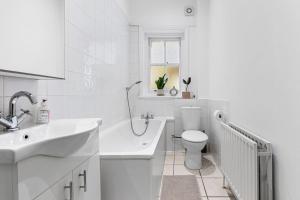 a white bathroom with a sink and a toilet at Maida Vale, Central Modern Apt, Sleeps 4, London. in London