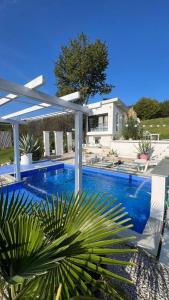 een groot zwembad met een witte pergola bij Calm House Villa in Prijedor