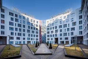 a courtyard in front of two white buildings at Central House Riverside Studio in Rīga