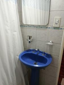 a blue sink in a bathroom with a shower curtain at Apreciando la montaña in Mendoza