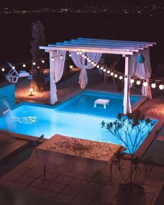 a swimming pool at night with a gazebo and a table at Calm House Villa in Prijedor