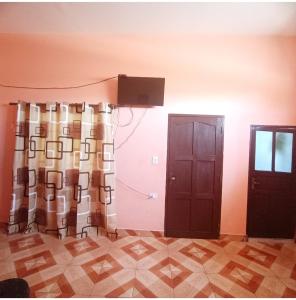 a room with two doors and a curtain and a television at Como en casa in Sucre