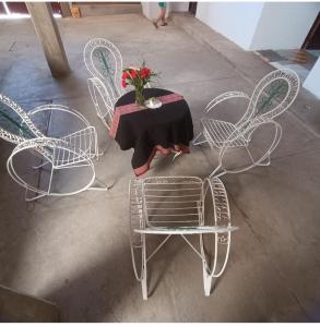 una mesa con sillas y un jarrón de flores. en Como en casa, en Sucre