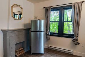 a stainless steel refrigerator in a room with a fireplace at Historical Building 1br 1ba Walk To Rogers Place in Edmonton