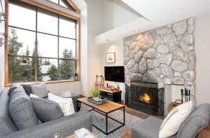 ein Wohnzimmer mit einem Sofa und einem Kamin in der Unterkunft Stoneridge 12 in Whistler