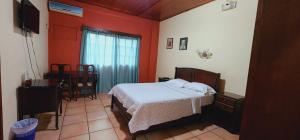 a bedroom with a bed in a room with red walls at Hotel Alsacia in Tegucigalpa