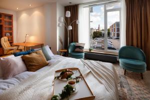 a hotel room with a bed and a large window at Central House Riverside Studio in Rīga