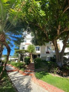 a white house with palm trees and a sidewalk at Luxury and Comfort in the heart of Vallarta in Puerto Vallarta