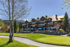 a large resort building with a stone wall at Lakeside Landing - Lake & Golf Course Views from Private Balcony - Whistler Platinum in Whistler