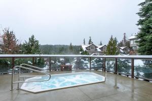 a jacuzzi tub on the balcony of a house at Blackcomb Greens 06 - Large Townhome, Golf Course Views, Shared Hot Tub - Whistler Platinum in Whistler