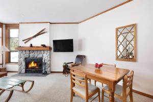 a living room with a table and a fireplace at Blackcomb Greens 06 - Large Townhome, Golf Course Views, Shared Hot Tub - Whistler Platinum in Whistler