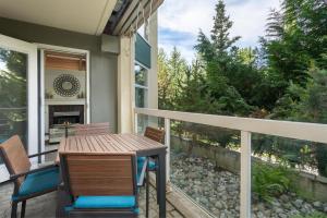 porche con mesa y sillas en el balcón en Woodrun Lodge 107 - Condo with Heated Pool, Hot Tub, Gym, Parking - Whistler Platinum, en Whistler