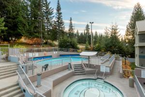 una piscina en un edificio con escaleras y una piscina en Woodrun Lodge 107 - Condo with Heated Pool, Hot Tub, Gym, Parking - Whistler Platinum, en Whistler
