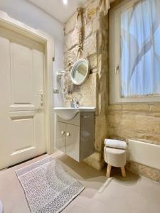 een badkamer met een wastafel, een bad en een spiegel bij LA SUITE DE TURRITAN in Sassari