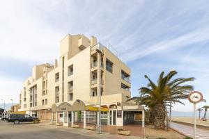 a tall building with a palm tree in front of it at Fantastic penthouse 270m2 with amazing sea views in Roquetas de Mar