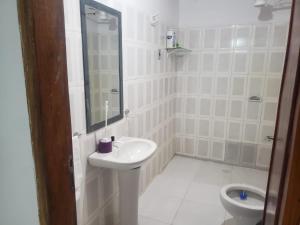 La salle de bains blanche est pourvue d'un lavabo et de toilettes. dans l'établissement Casa amoblada en Villarrica - Py, à Villarrica