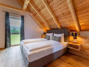 a bedroom with a large bed and a large window at Mountain Chalet Bergfreund in Sankt Lorenzen ob Murau