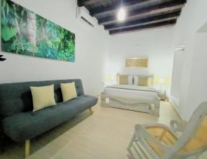 ein Schlafzimmer mit einem Sofa und einem Bett in einem Zimmer in der Unterkunft Hotel AT THE PARK in Cartagena de Indias