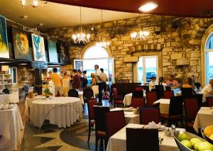 a restaurant with tables and people in a stone wall at PiranArt Boutique Hotel & More in Piran