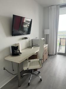a room with a desk with a tv on the wall at 23rd floor Luxury & Spacious BeachWalk Resort Apartment with Amazing View in Hallandale Beach