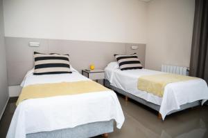 2 camas en una habitación con almohadas blancas y negras en Apartamento Pescara 60 en Maipú