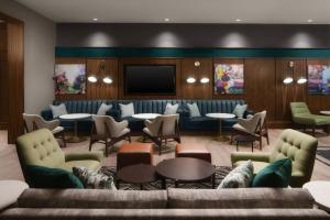 a lobby with couches and tables and a tv at Courtyard by Marriott Gainesville GA in Gainesville
