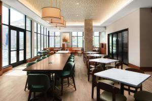 un restaurante con mesas, sillas y ventanas en Courtyard by Marriott Gainesville GA, en Gainesville