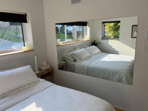 a bedroom with two beds and a large mirror at Magical Loft : Breathtaking View & Cozy Fireplace in Saguenay