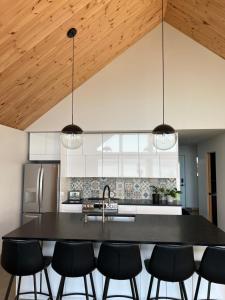 a kitchen with a black table and black chairs at Magical Loft : Breathtaking View & Cozy Fireplace in Saguenay