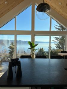 a large room with a table and a large window at Magical Loft : Breathtaking View & Cozy Fireplace in Saguenay