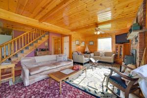 ein Wohnzimmer mit einem Sofa und einer Treppe in der Unterkunft Riverfront Cheboygan Cabin with Kayaks and Dock! in Cheboygan