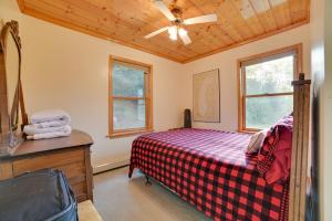 Schlafzimmer mit einem Bett und einem Deckenventilator in der Unterkunft Riverfront Cheboygan Cabin with Kayaks and Dock! in Cheboygan