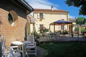 a patio with a table and chairs and an umbrella at B&B Il Giardino in Tavullia