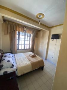 a bedroom with a large bed and a window at Departamento en zona céntrica de Yacuiba in Yacuiba