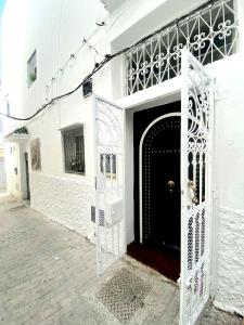 een wit gebouw met een poort ervoor bij Magnifique Riad Privé Au Centre Du Medina - Double terrace privé in Tanger