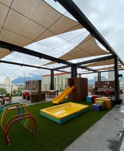 a play area with awning and slides on a roof at Lux 2 bedroom apartment, swimming pool, gym and free parking spot in Macro Plaza area in Monterrey