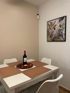 una mesa con una botella de vino y un plato de comida en Altemar, two bedrooms las americas en Arona