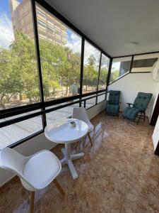 a room with a table and chairs and windows at Altemar, two bedrooms las americas in Arona