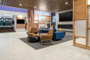 a lobby with a blue couch and chairs and a tv at Fairfield by Marriott Inn & Suites Corinth South Denton Area in Corinth