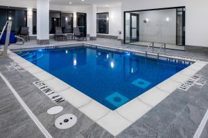 een zwembad met blauw water in een gebouw bij Fairfield by Marriott Inn & Suites Corinth South Denton Area in Corinth