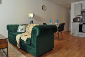 a living room with a green couch and a table at Select SA - Queens Terrace in Reading