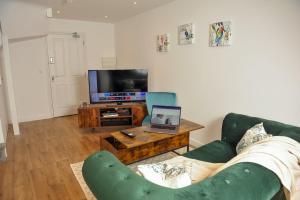 a living room with a couch and a laptop on a coffee table at Select SA - Queens Terrace in Reading