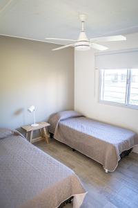 una camera da letto con due letti e un ventilatore a soffitto di Casa quinta Los Teros a Junín Altre 49 foto