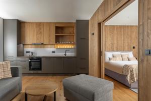1 dormitorio con cama, sofá y cocina en Aldrov Resort en Vítkovice
